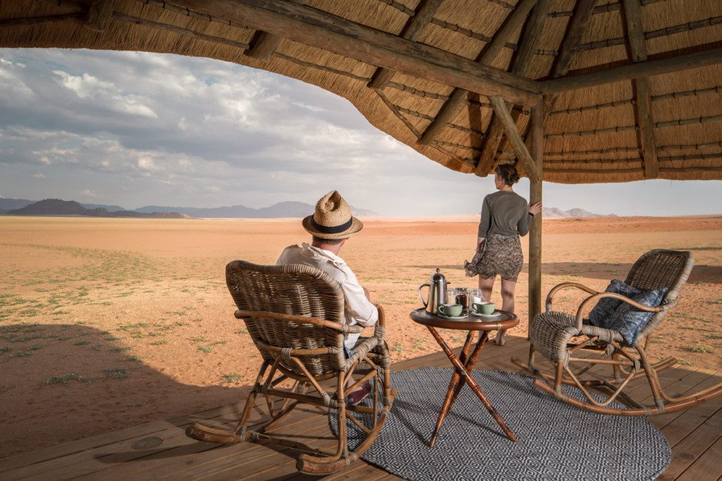 Couple admire the view at Kwessi dunes a great base from which to explore the Namib desert and Sossuvlei in Namibia