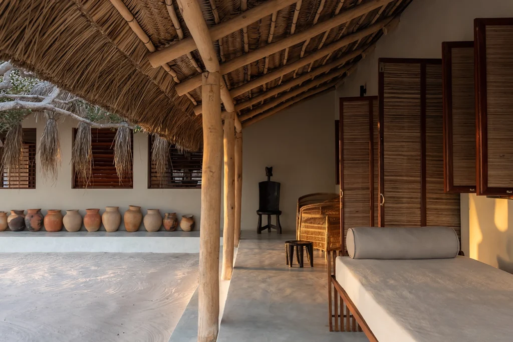 Patio details at a beach lodge with thatch roof and clay pots as decor.