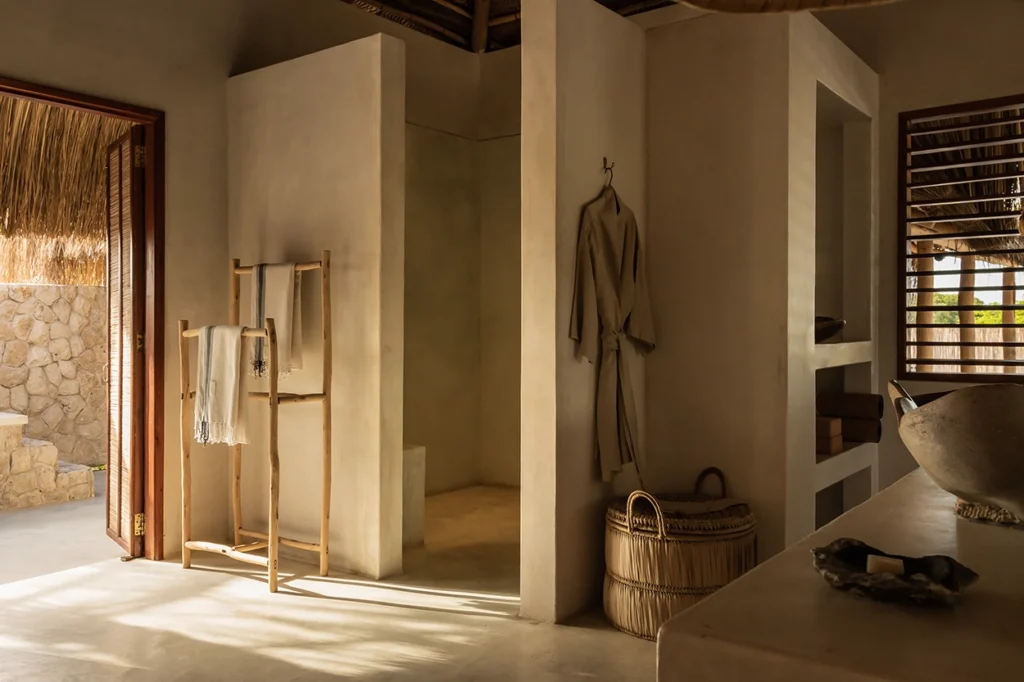 Bathroom details at a beach lodge with a doorway to an outdoor bath.