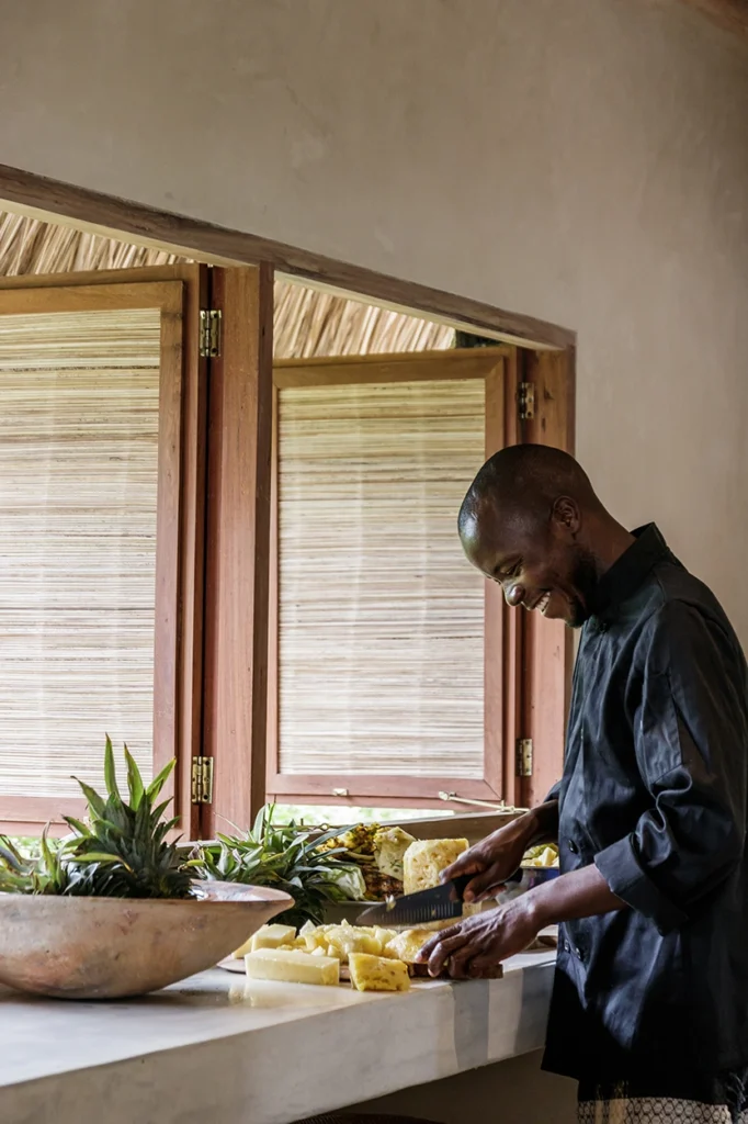 Chef cutting a pineapple in a neutral, open kitchen in mozambique.